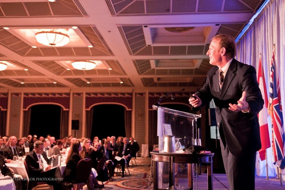 Mark Thompson delivering a keynote to a seated ballroom audience